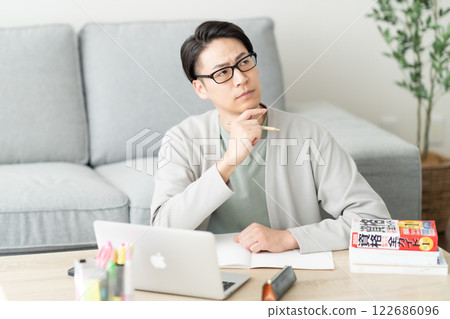 一名 30 多歲的男子正在閱讀一本關於重新學習技能的參考書，他擔心 122686096