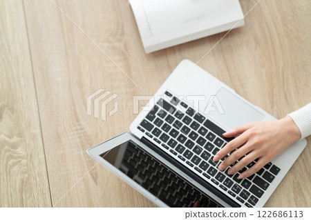 客廳裡有位女士在電腦上打字，沒有臉 122686113