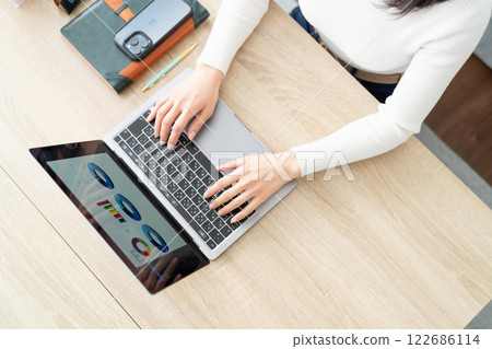 客廳裡有位女士在電腦上打字，沒有臉 122686114