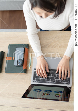 客廳裡有位女士在電腦上打字，沒有臉 122686115