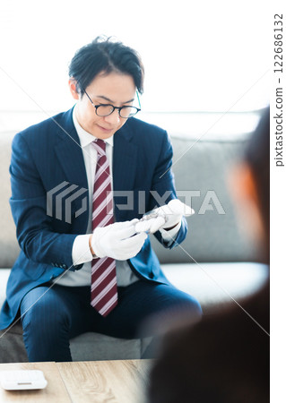 A male businessman visiting a major customer at his home 122686132