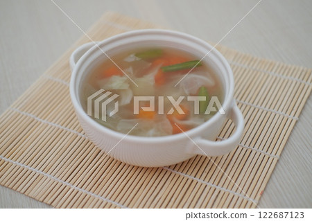 A bowl of fresh soup on a table 122687123