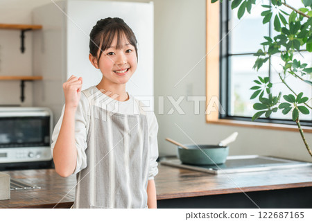 在家裡的廚房裡穿著圍裙的小學和國中女孩 122687165