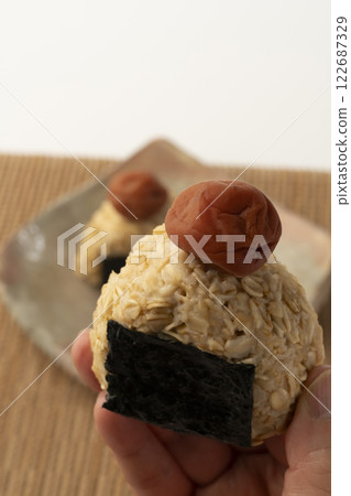 用手抓起一個燕麥飯糰 122687329