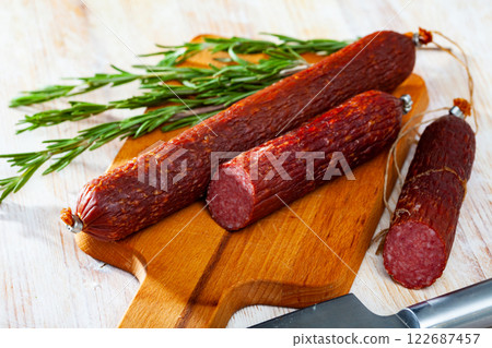 Close-up of smoked russian sausage at wooden surface Close-up of smoked russian sausage at wooden surface 122687457