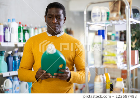 Male consumer with household chemical products for washing indoors Male consumer with household chemical products for washing indoors 122687488
