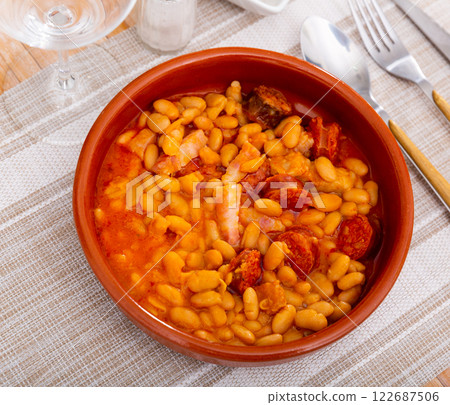 Dish of Spanish cuisine Alubias con chorizo, beans in tomato sauce with sausage chorizo served on plate Dish of Spanish cuisine Alubias con chorizo, beans in tomato sauce with sausage chorizo served on plate 122687506