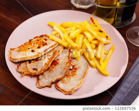 Roasted pork tenderloin served with fried potato 122687536