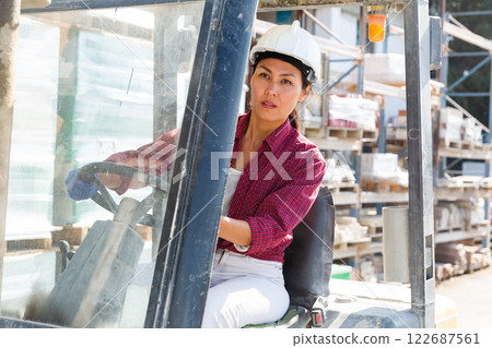Asian woman working on forklift at construction store Asian woman working on forklift at construction store 122687561