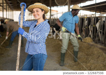 Latino american female farmer standing at the cow farm Latino american female farmer standing at the cow farm 122687598