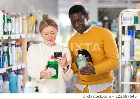 African man and European woman spouses buyer scan QR code on packaging of dishwashing soap in shop African man and European woman spouses buyer scan QR code on packaging of dishwashing soap in shop 122687646