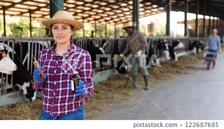 Woman farmer standing with syringe at farm Woman farmer standing with syringe at farm 122687685