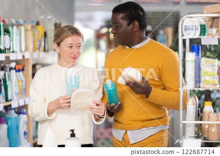 During shopping, African male client with wife advised and choose shampoo, shower gel, bast wisp During shopping, African male client with wife advised and choose shampoo, shower gel, bast wisp 122687714
