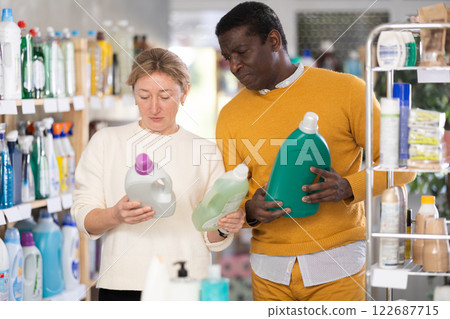 Couple man and woman choosing detergent in store Couple man and woman choosing detergent in store 122687715