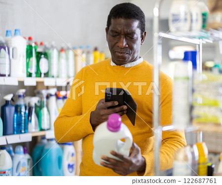 Checking expiration date of detegrent - male shopper scans QR code on label of detegrent using smartphone Checking expiration date of detegrent - male shopper scans QR code on label of detegrent using smartphone 122687761