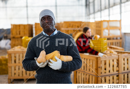 Male farmer posing with pumpkins Male farmer posing with pumpkins 122687785