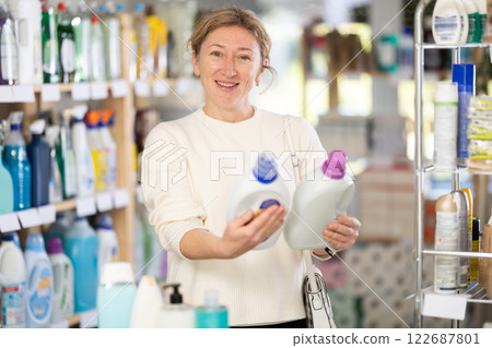 Adult woman buyer chooses detergent in store Adult woman buyer chooses detergent in store 122687801