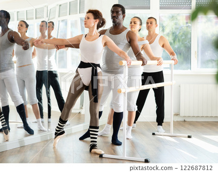 Group of dancers practicing batman tandu at barre 122687812