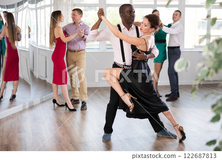 Woman dances incendiary tango with African man partner during choreography lesson 122687813
