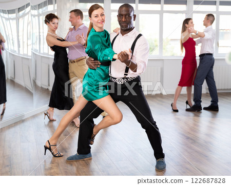 Woman dances incendiary tango with African man partner during choreography lesson 122687828