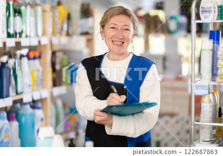 Female manager of hardware store keeps track of goods on supermarket shelves Female manager of hardware store keeps track of goods on supermarket shelves 122687863