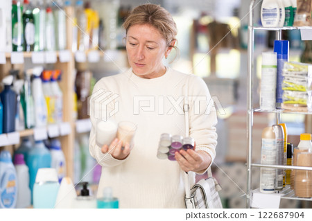 Adult woman choosing scented candles in store 122687904