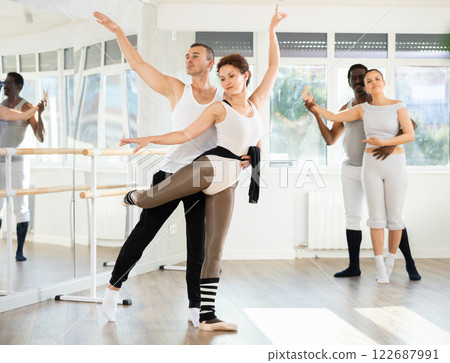 Man and girl woman together arabesque position of ballet during choreography studio 122687991