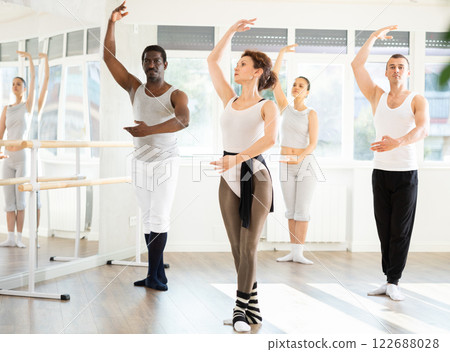Graceful woman leading ballet class with adult amateur dancers 122688028