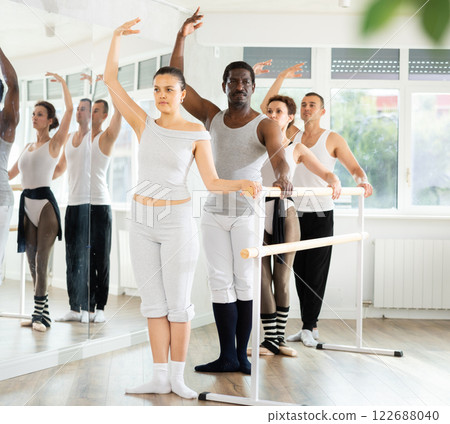 Group of dancers stand in third position at barre Group of dancers stand in third position at barre 122688040