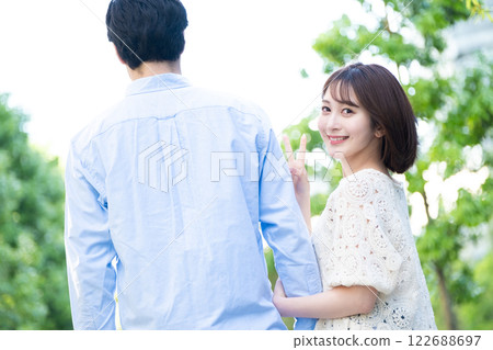 一位女士轉身做出和平手勢，男女情侶形象 122688697