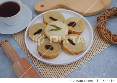 Kue Lumpur or Mud Cake, Indonesian traditional cake made from potato, flour, eggs and coconut milk topped with raisins served on plate. beautiful decoration Kue Lumpur or Mud Cake, Indonesian traditional cake made from potato, flour, eggs and coconut milk topped with raisins served on plate. beautiful decoration 122688812