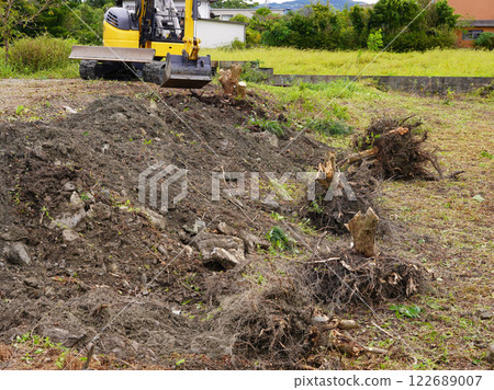 重型機械清除在土地開發前被砍伐的樹木的根部。 重型機械清除在土地開發前被砍伐的樹木的根部。 122689007