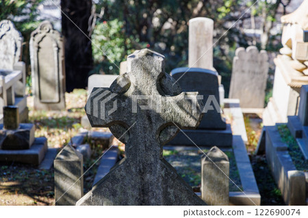 Gravestone with a cross in a cemetery 122690074