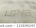 Writing letter love on sand. 122690245
