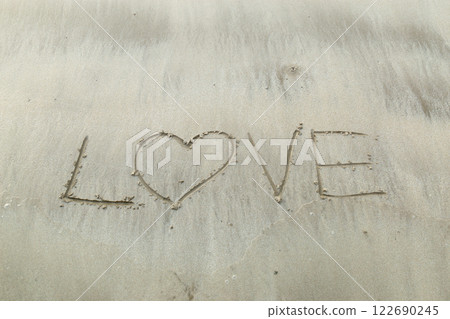 Writing letter love on sand. Writing letter love on sand. 122690245