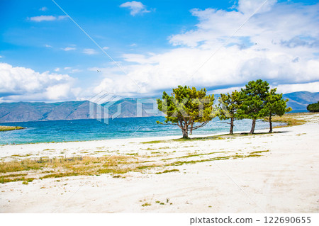Sandy beach. Seaside vacation, golden beaches. Blue waters of the sea. Lake, ocean, sea Sandy beach. Seaside vacation, golden beaches. Blue waters of the sea. Lake, ocean, sea 122690655