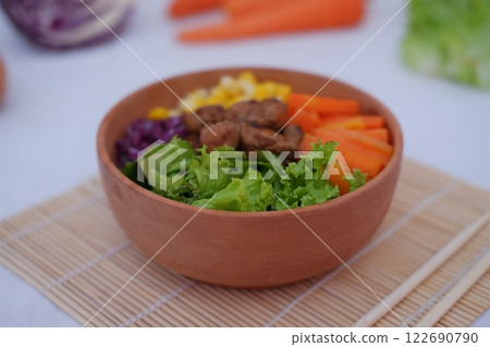 A vibrant meal consisting of red rice, meat, corn, carrots, lettuce, and a sunny side A vibrant meal consisting of red rice, meat, corn, carrots, lettuce, and a sunny side 122690790