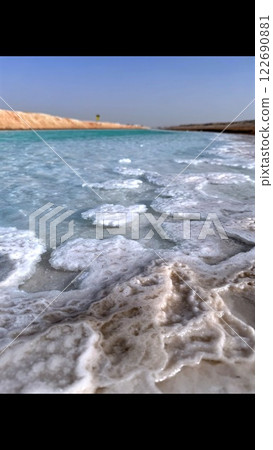 Salt and water work together to create mesmerizing coastal landscapes. Minerals form intricate formations along shorelines, enhancing beauty of natural environments shaped by elements. 122690881