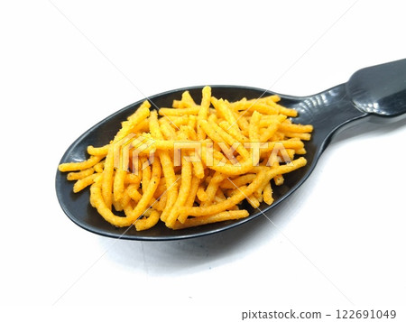 A picture of aloo bhujia on a black spoon 122691049
