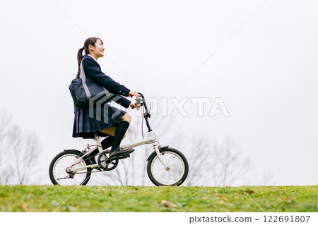 Junior high and high school girls in uniforms commuting to school by bicycle Junior high and high school girls in uniforms commuting to school by bicycle 122691807