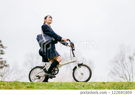 Junior high and high school girls in uniforms commuting to school by bicycle 122691809
