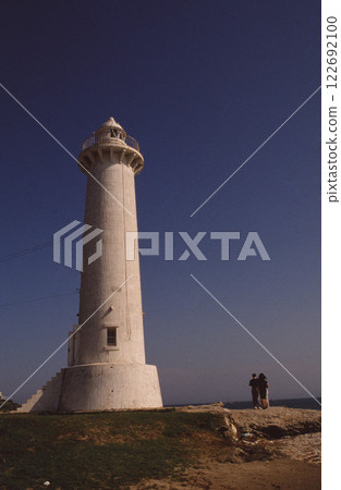 Tourists watching the lighthouse at sunset Tourists watching the lighthouse at sunset 122692100