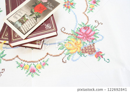 A warm scene of cross stitch and vintage books A warm scene of cross stitch and vintage books 122692841