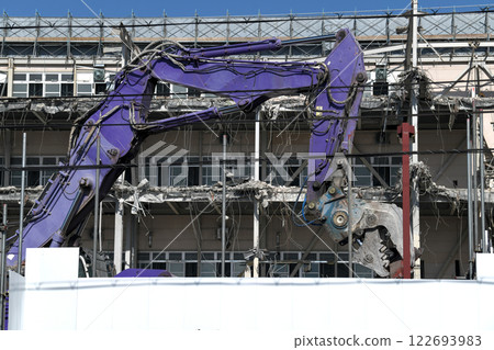 A hydraulic crusher at work at a factory demolition site 122693983