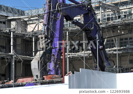 A hydraulic crusher at work at a factory demolition site 122693986