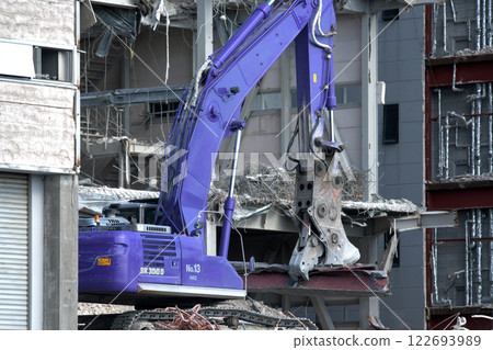 A hydraulic crusher at work at a factory demolition site 122693989