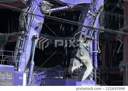 A hydraulic crusher at work at a factory demolition site A hydraulic crusher at work at a factory demolition site 122693996