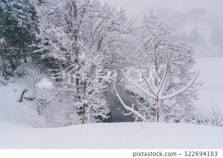 River flowing through a snowy valley 122694183