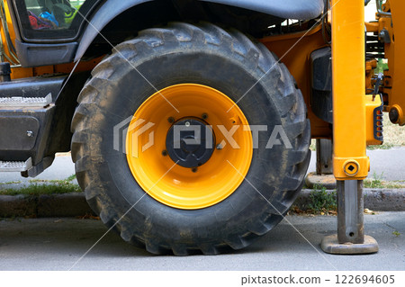 Lifting machine truck crane stands on stops, a large wheel of a tractor Lifting machine truck crane stands on stops, a large wheel of a tractor 122694605