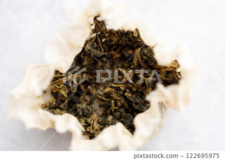 Closeup of dry tea bag on white table background. Closeup of dry tea bag on white table background. 122695975